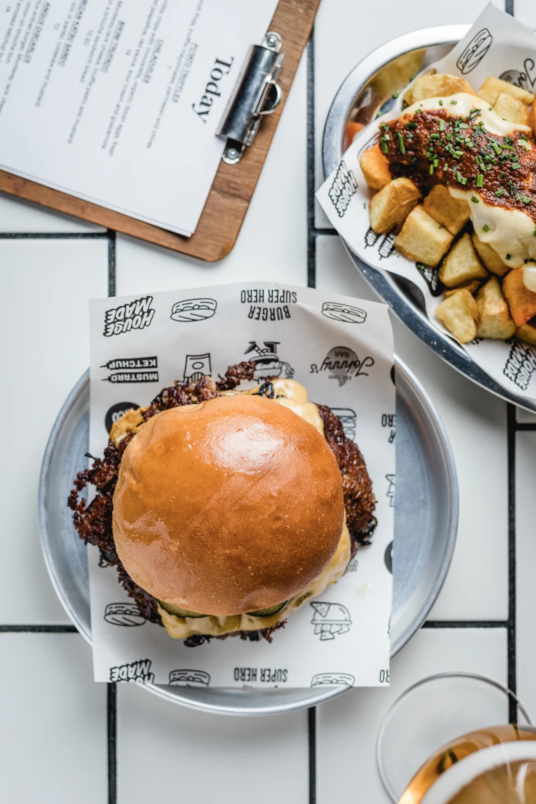 Burger de Johnny's con patatas bravas y la carta del día, vista cenital