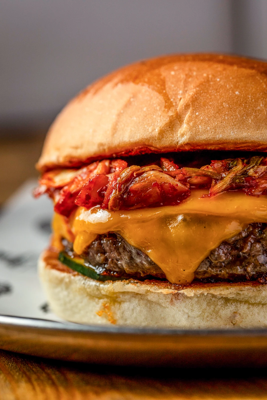 Primer plano de burger con cheddar fundido y kimchi